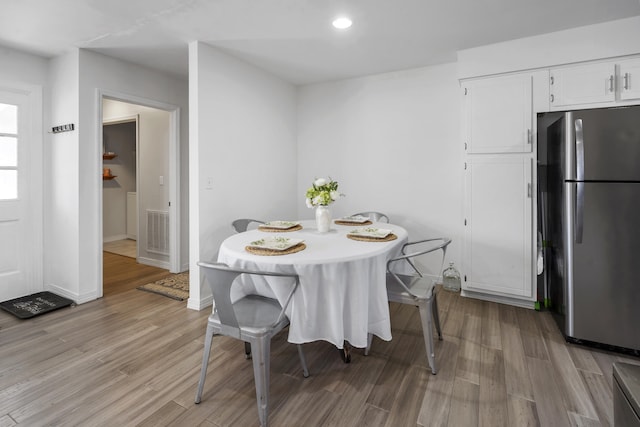 dining room featuring light wood-style flooring, visible vents, baseboards, and recessed lighting