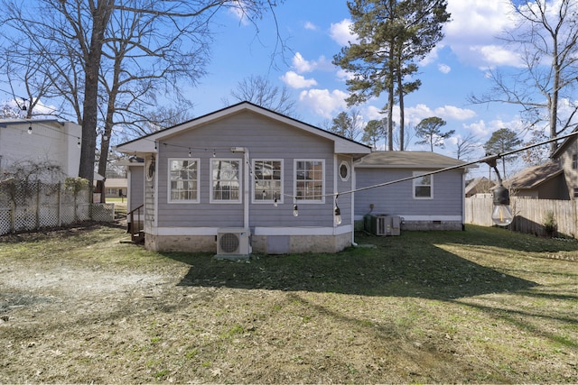 rear view of property with crawl space, ac unit, fence, and a yard