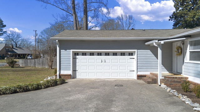 garage with driveway and fence