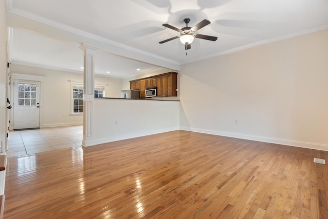 unfurnished living room featuring ornamental molding, ceiling fan, and light hardwood / wood-style floors