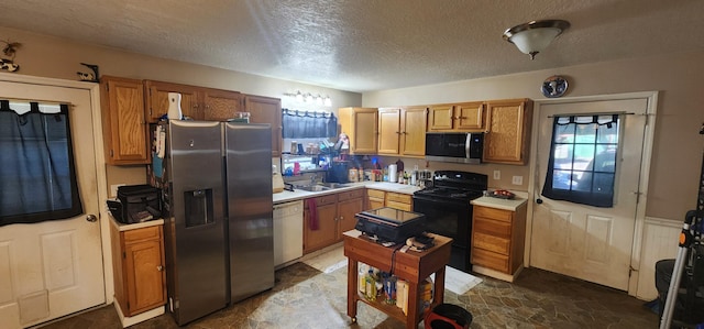 kitchen featuring appliances with stainless steel finishes, sink, and a textured ceiling