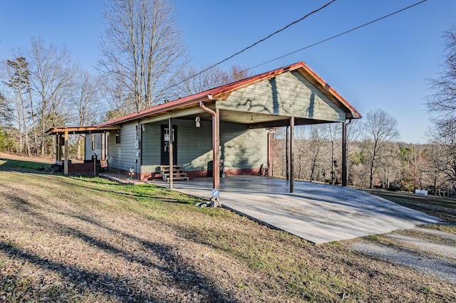 exterior space with a carport, a lawn, driveway, and entry steps