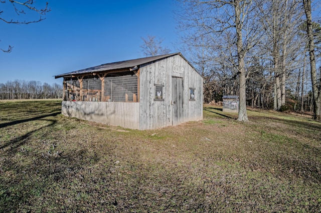 view of home's exterior featuring a lawn and an outdoor structure