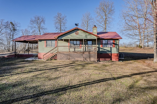 view of front of property featuring covered porch, a front yard, metal roof, a carport, and a chimney