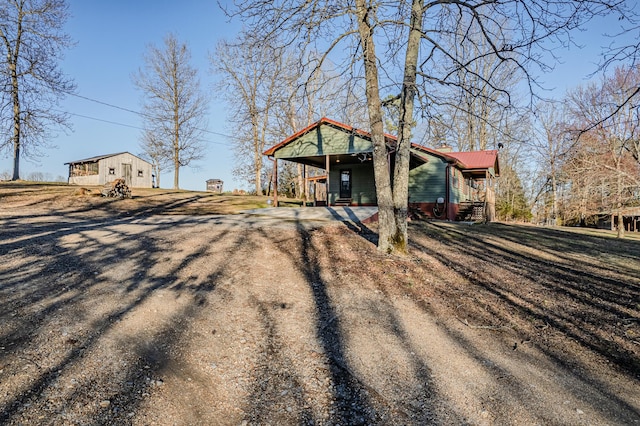 view of front of house featuring a carport, driveway, metal roof, and a front lawn