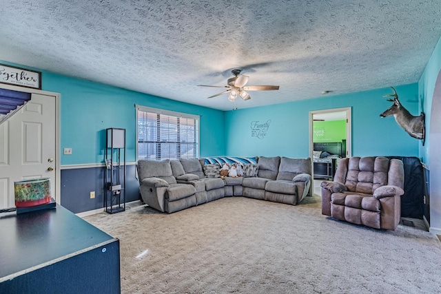 carpeted living room with a ceiling fan and a textured ceiling