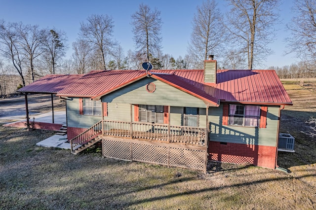 rear view of property featuring a porch, central AC unit, a chimney, metal roof, and crawl space