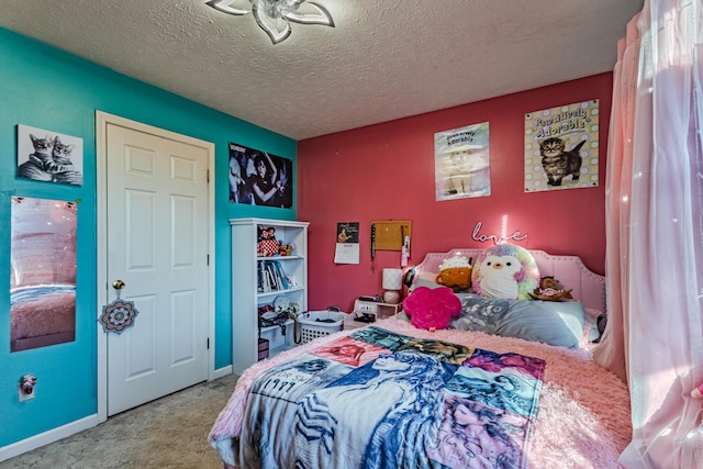 bedroom with carpet, baseboards, and a textured ceiling