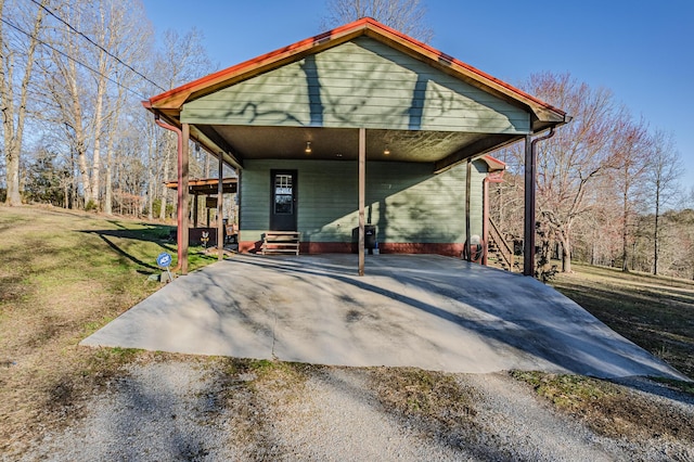 rear view of house with a lawn, entry steps, and gravel driveway