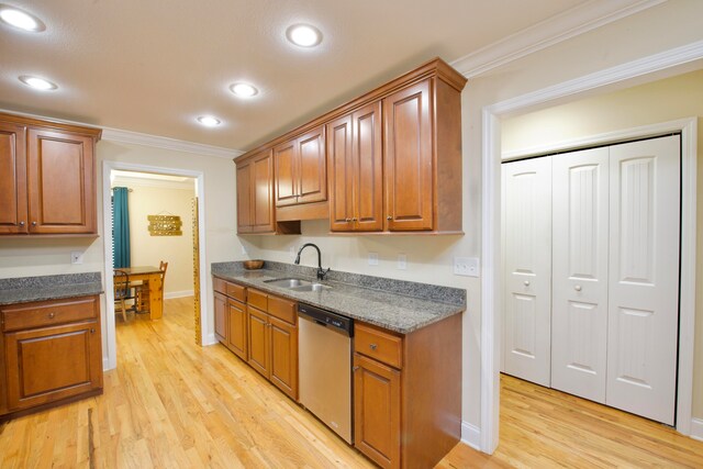 kitchen featuring dishwasher, dark stone counters, crown molding, sink, and light hardwood / wood-style flooring