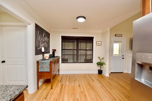 foyer with light hardwood / wood-style flooring and ornamental molding