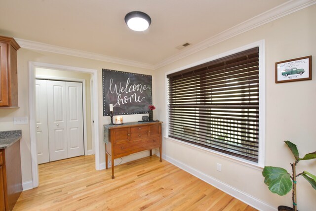 interior space with light hardwood / wood-style floors and ornamental molding