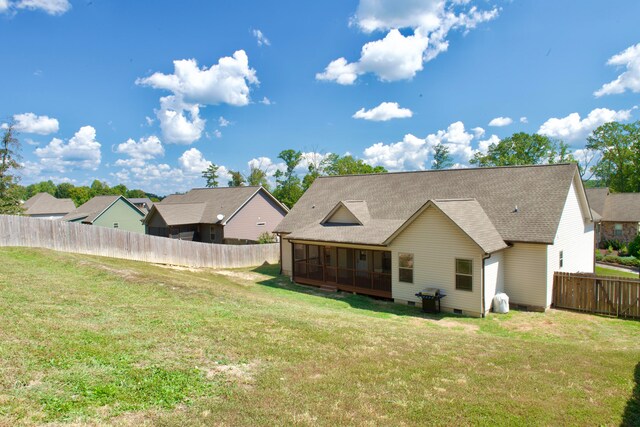 back of house featuring a yard and a sunroom