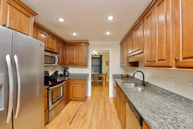 kitchen with sink, an inviting chandelier, light hardwood / wood-style flooring, crown molding, and appliances with stainless steel finishes