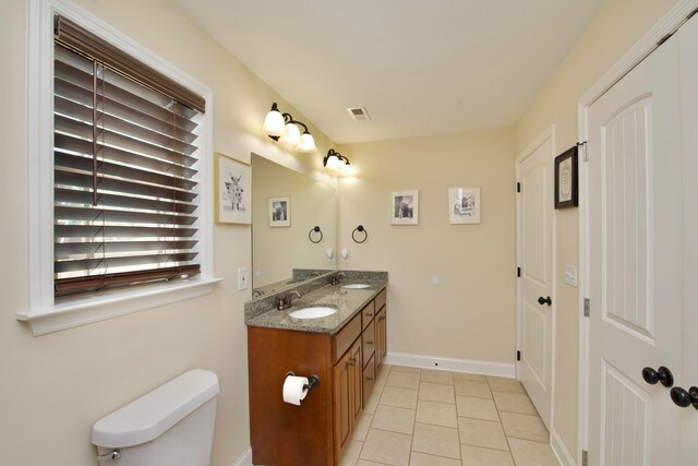 bathroom with tile patterned flooring, vanity, and toilet