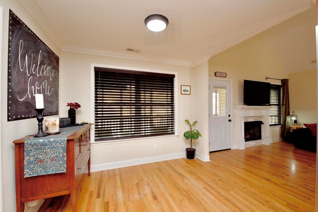 foyer featuring crown molding, vaulted ceiling, and hardwood / wood-style flooring