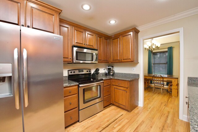 kitchen featuring a chandelier, appliances with stainless steel finishes, light hardwood / wood-style flooring, and ornamental molding