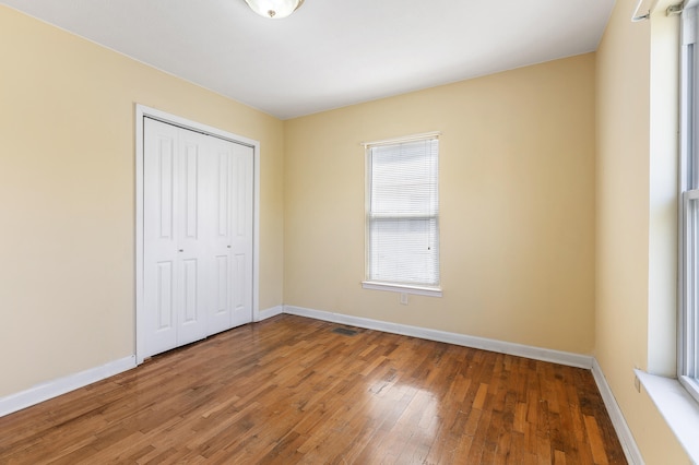 unfurnished bedroom with wood-type flooring and a closet