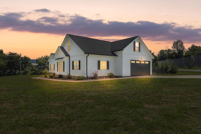 modern farmhouse style home featuring a lawn and a garage