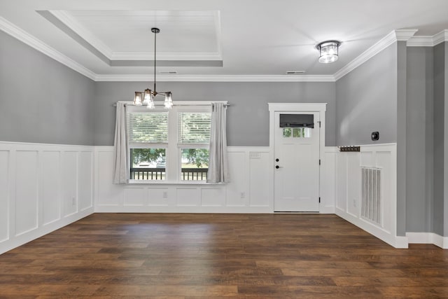 entrance foyer with a tray ceiling, crown molding, dark hardwood / wood-style floors, and an inviting chandelier