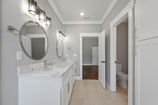 bathroom with hardwood / wood-style floors, vanity, toilet, and ornamental molding