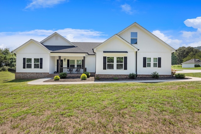 modern farmhouse style home featuring covered porch and a front lawn