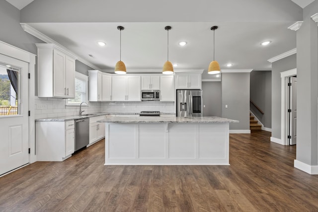 kitchen featuring a center island, white cabinets, hanging light fixtures, sink, and appliances with stainless steel finishes