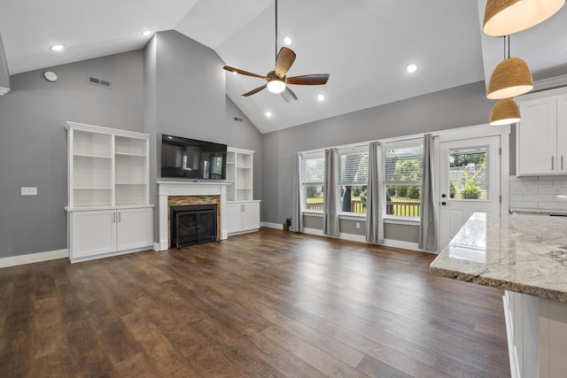 unfurnished living room featuring dark hardwood / wood-style floors, high vaulted ceiling, and ceiling fan