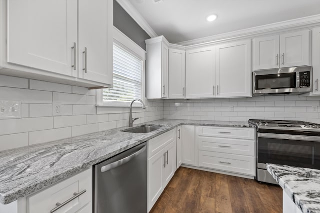 kitchen featuring backsplash, stainless steel appliances, dark wood-type flooring, sink, and white cabinetry