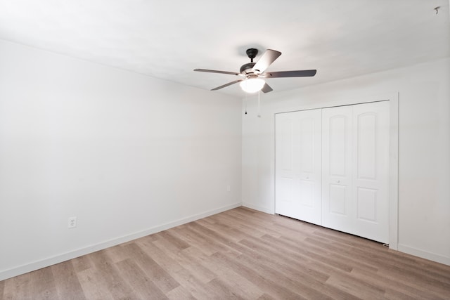 unfurnished bedroom with ceiling fan, a closet, and light wood-type flooring