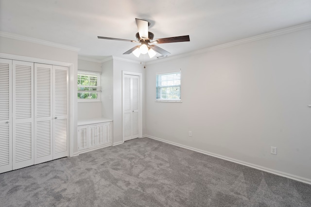 unfurnished bedroom with multiple windows, light carpet, two closets, and ceiling fan