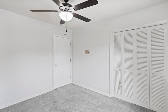 unfurnished bedroom featuring ceiling fan, a closet, and light colored carpet