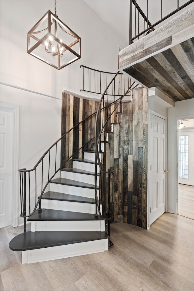 stairway with hardwood / wood-style floors, wooden ceiling, and a notable chandelier