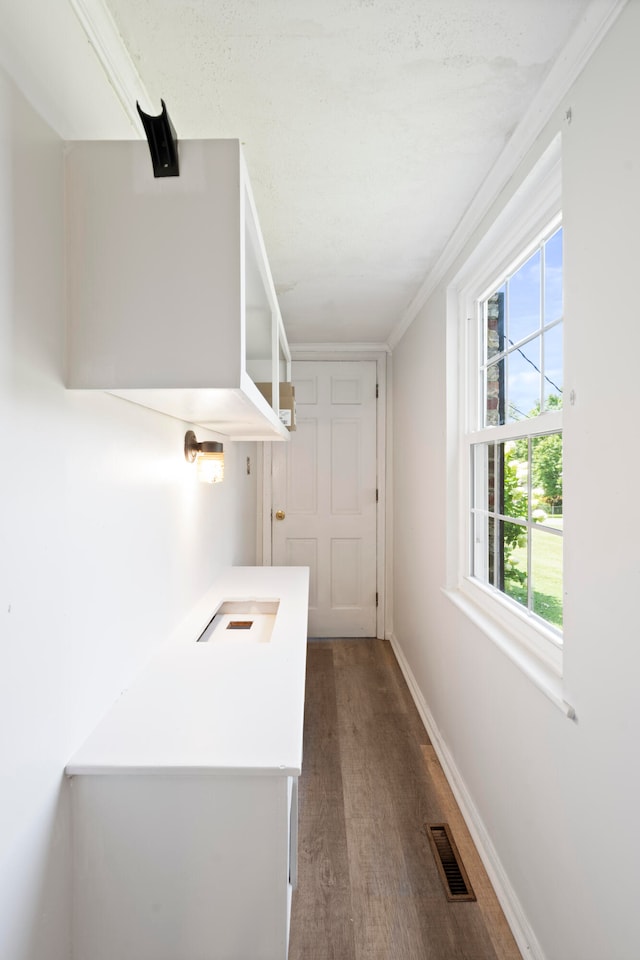 hallway with hardwood / wood-style floors and ornamental molding