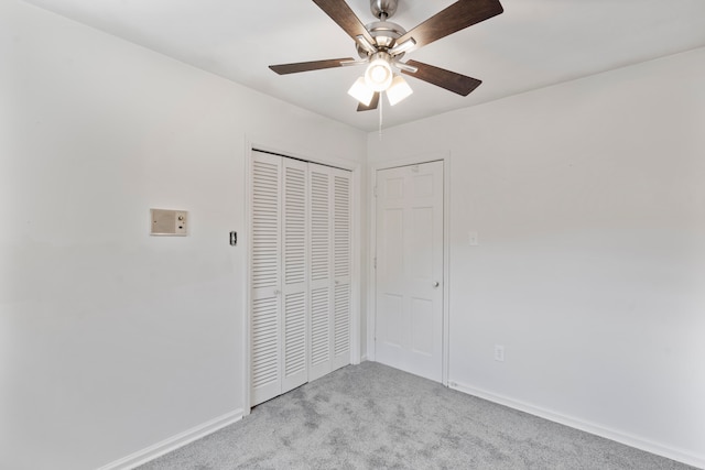 unfurnished bedroom with ceiling fan, light colored carpet, and a closet