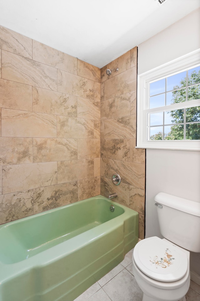 bathroom featuring toilet, tile patterned flooring, and tiled shower / bath