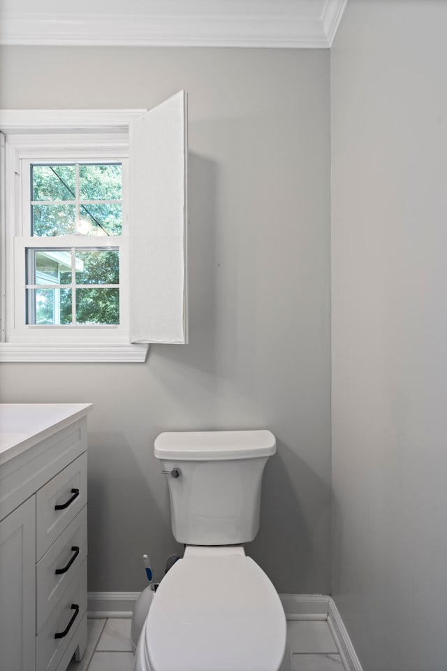 bathroom with tile patterned floors, vanity, toilet, and ornamental molding