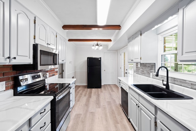 kitchen featuring appliances with stainless steel finishes, light wood-type flooring, sink, beamed ceiling, and white cabinetry