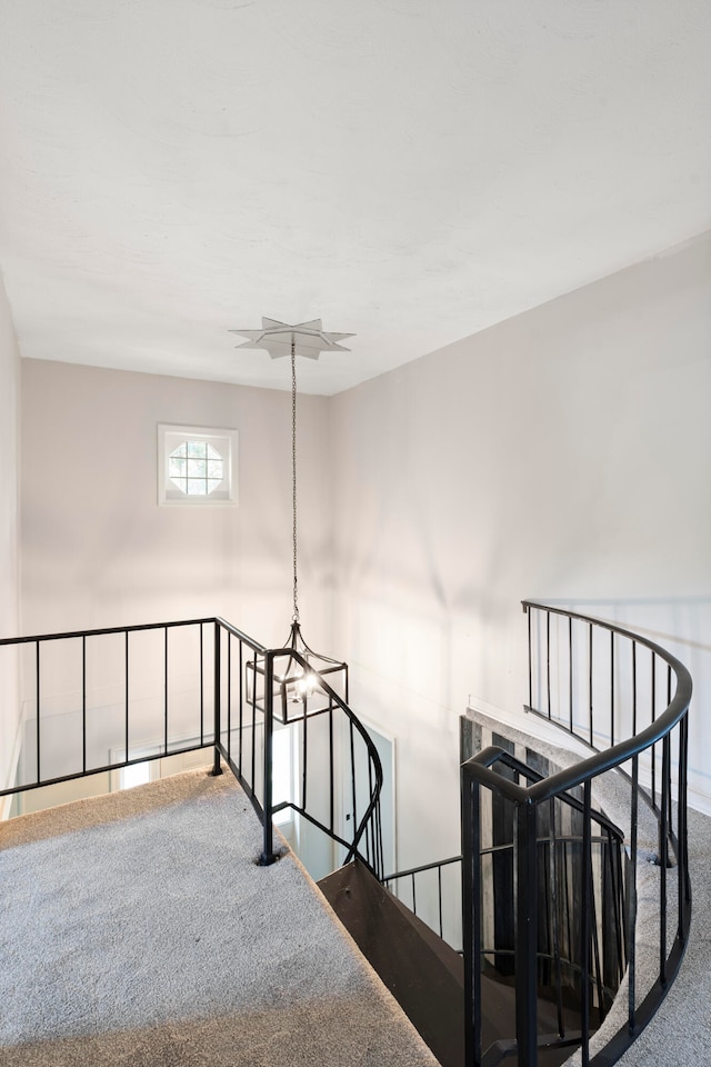 staircase with carpet and a chandelier