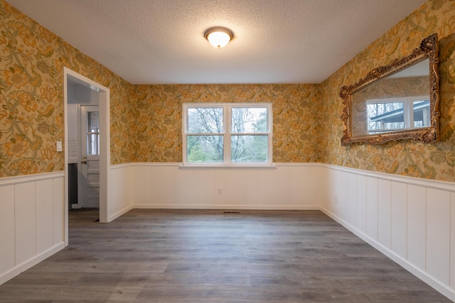 spare room with dark hardwood / wood-style floors and a textured ceiling