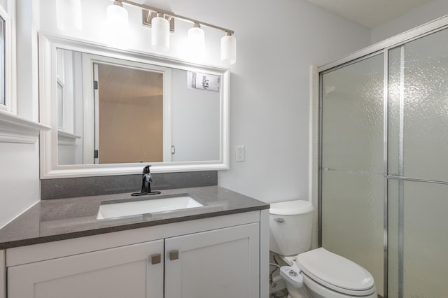 bathroom with toilet, vanity, and walk in shower