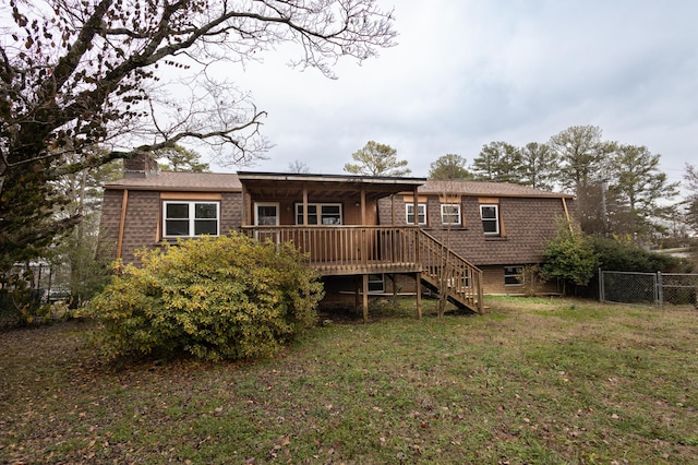 back of property with a yard and a wooden deck