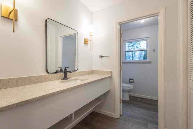 bathroom with hardwood / wood-style floors, vanity, and toilet