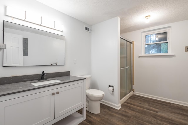 bathroom with a shower with door, vanity, wood-type flooring, and a textured ceiling