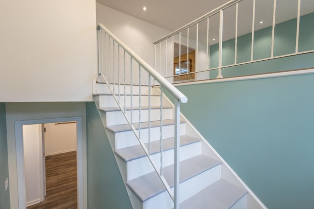 stairway featuring wood finished floors and recessed lighting