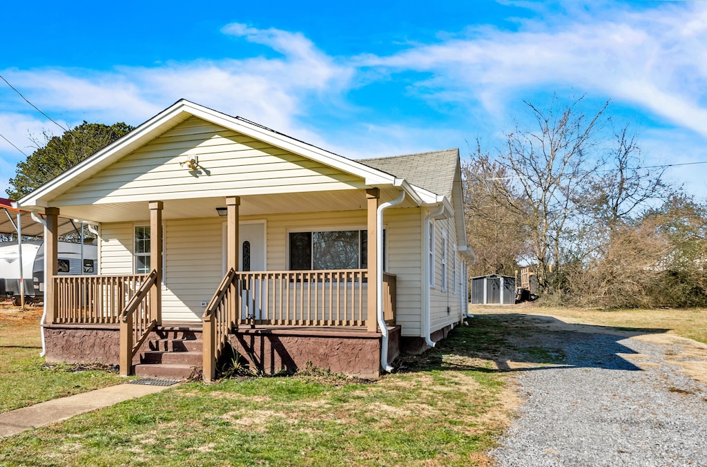 bungalow-style house with covered porch and a front lawn