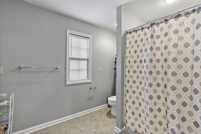 bathroom with tile patterned flooring, a shower with curtain, and toilet