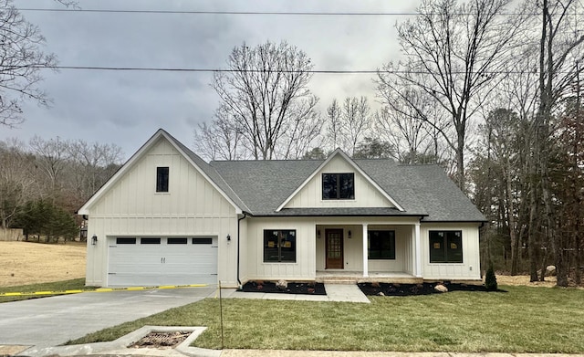 modern farmhouse style home featuring a front yard, a porch, and a garage