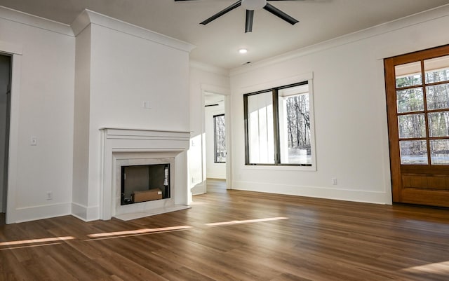 unfurnished living room featuring plenty of natural light, ornamental molding, and dark hardwood / wood-style floors