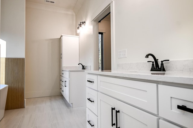 bathroom featuring vanity and ornamental molding